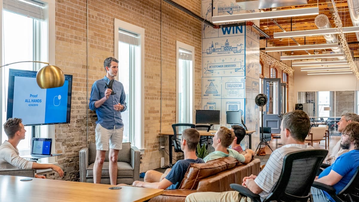 A B2B sales team collaborating around a laptop in a modern office
